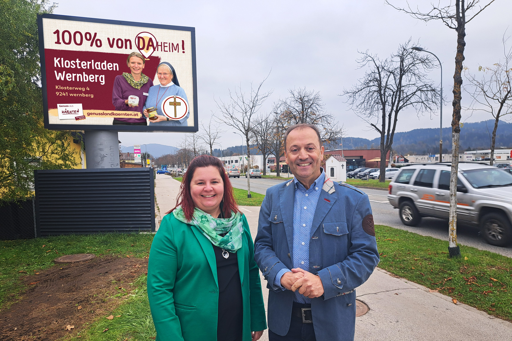 Andreas Lanner und Petra Pobaschnig vor einer LED-Wall mit einer Grafik von Genussland Kärnten